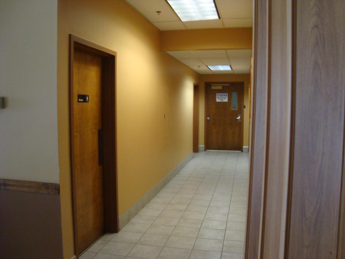 hallway with fluorescent lights and doors